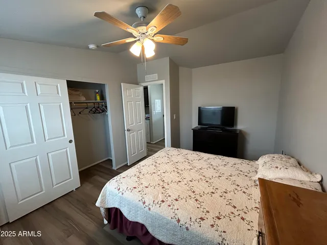 a bedroom with a bed and a flat tv screen on a dresser