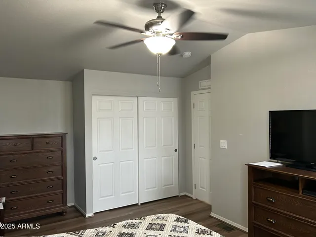 a bedroom with a bed and wooden floor