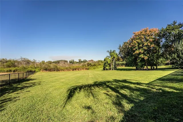 an aerial view of residential houses with outdoor space and trees