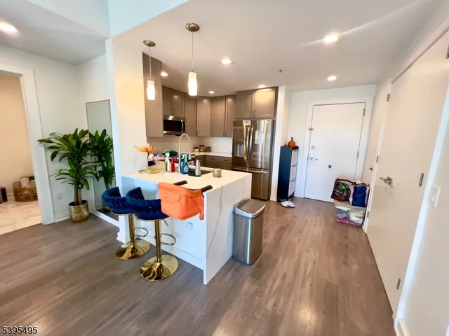 a room with stainless steel appliances a dining table chairs a sink and a refrigerator