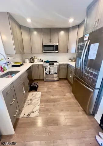 a large kitchen with stainless steel appliances kitchen island granite countertop a sink stove and refrigerator