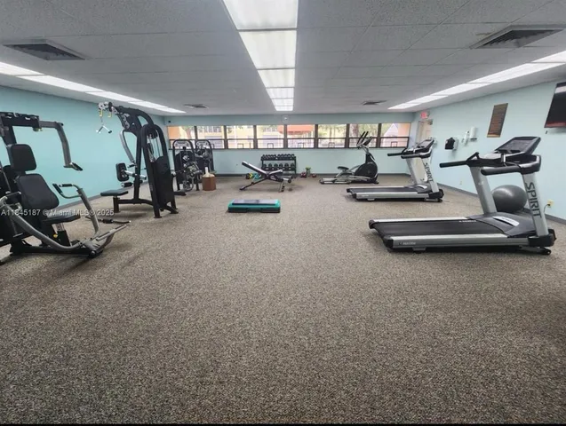 a gym room with gym equipment and a large window