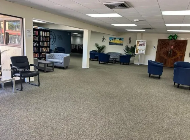 a living room with furniture and a bookshelf