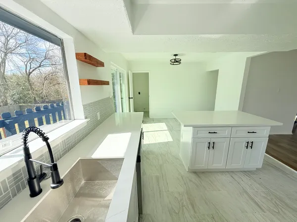 a living room with stainless steel appliances furniture and a large window