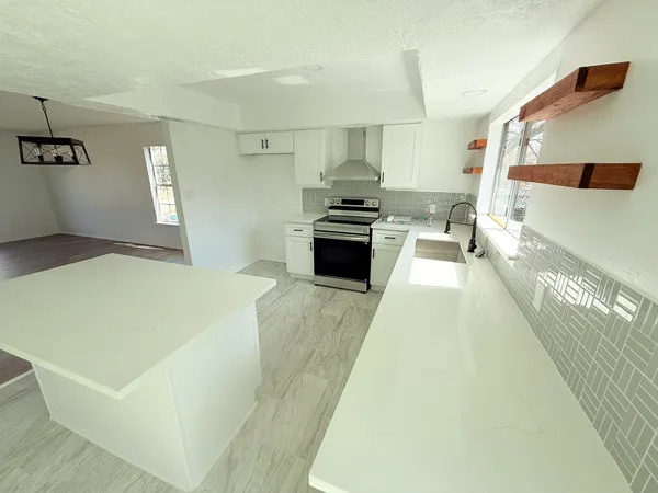 a large white kitchen with cabinets