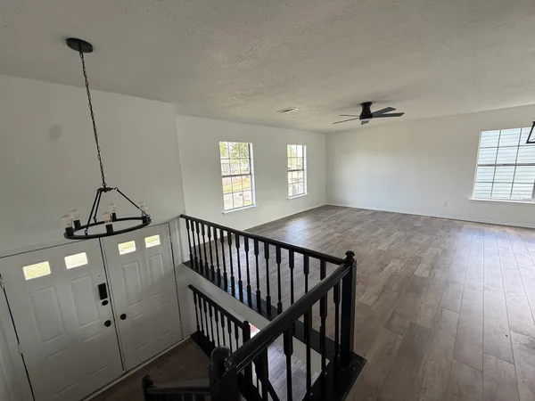 a view of a hallway with windows and chandelier