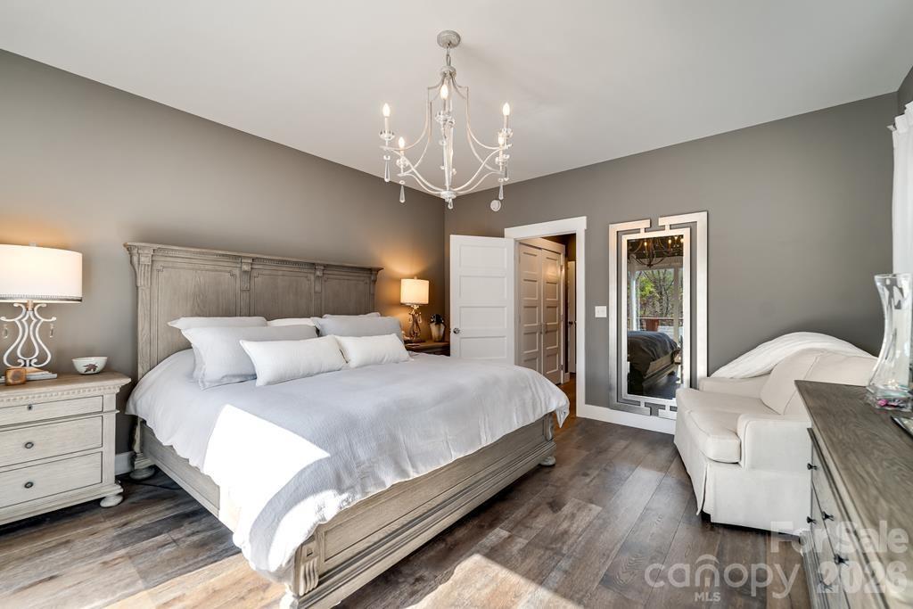 117 Amberleaf Way Cullowhee, NC 28723 - Photo 21 of 48 a spacious bedroom with a bed chandelier and a window