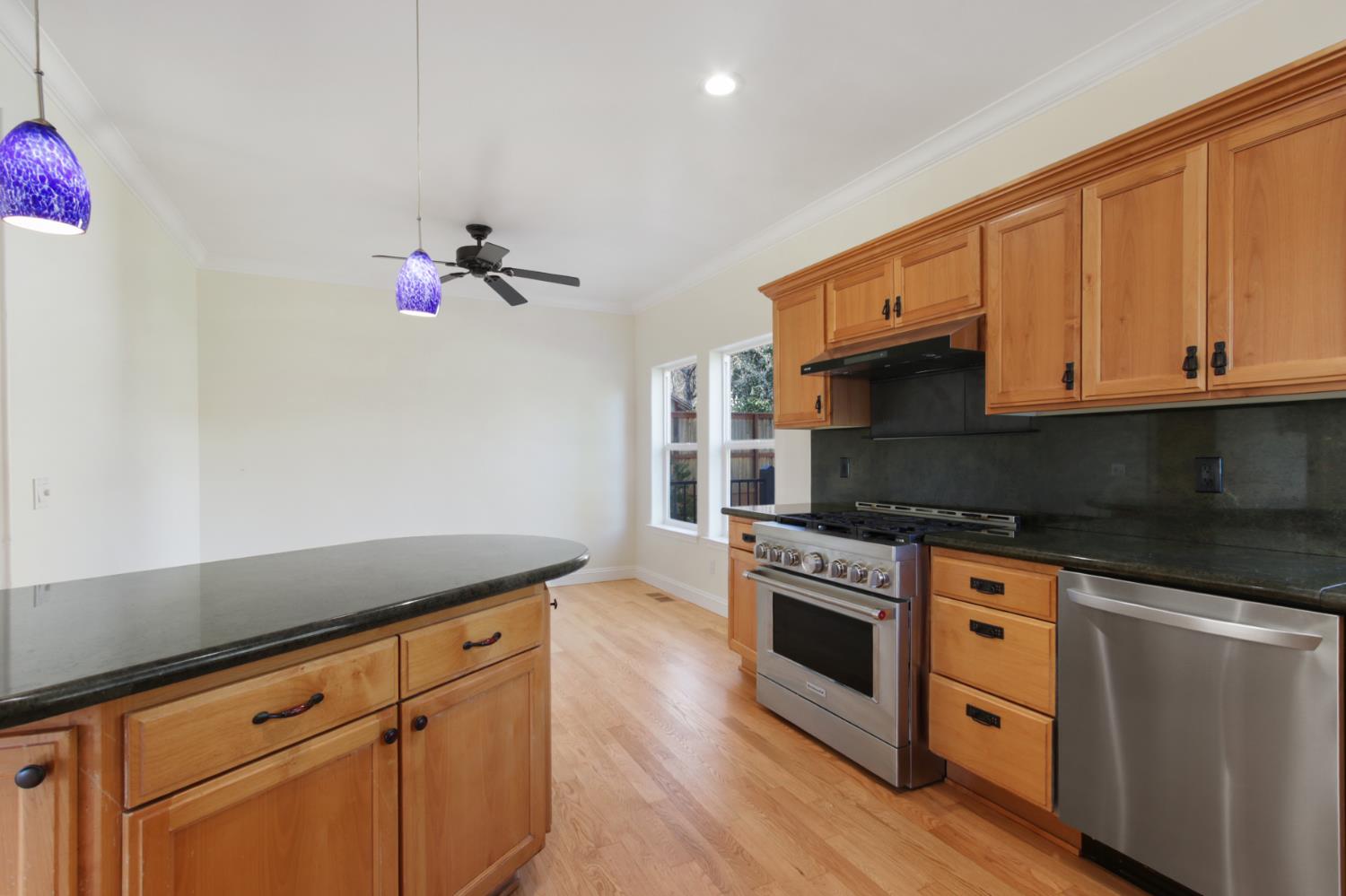 12930 Ridge Road Grass Valley, CA 95945 - Photo 22 of 62 a kitchen with granite countertop a stove top oven a sink dishwasher and a microwave oven on the wooden floor