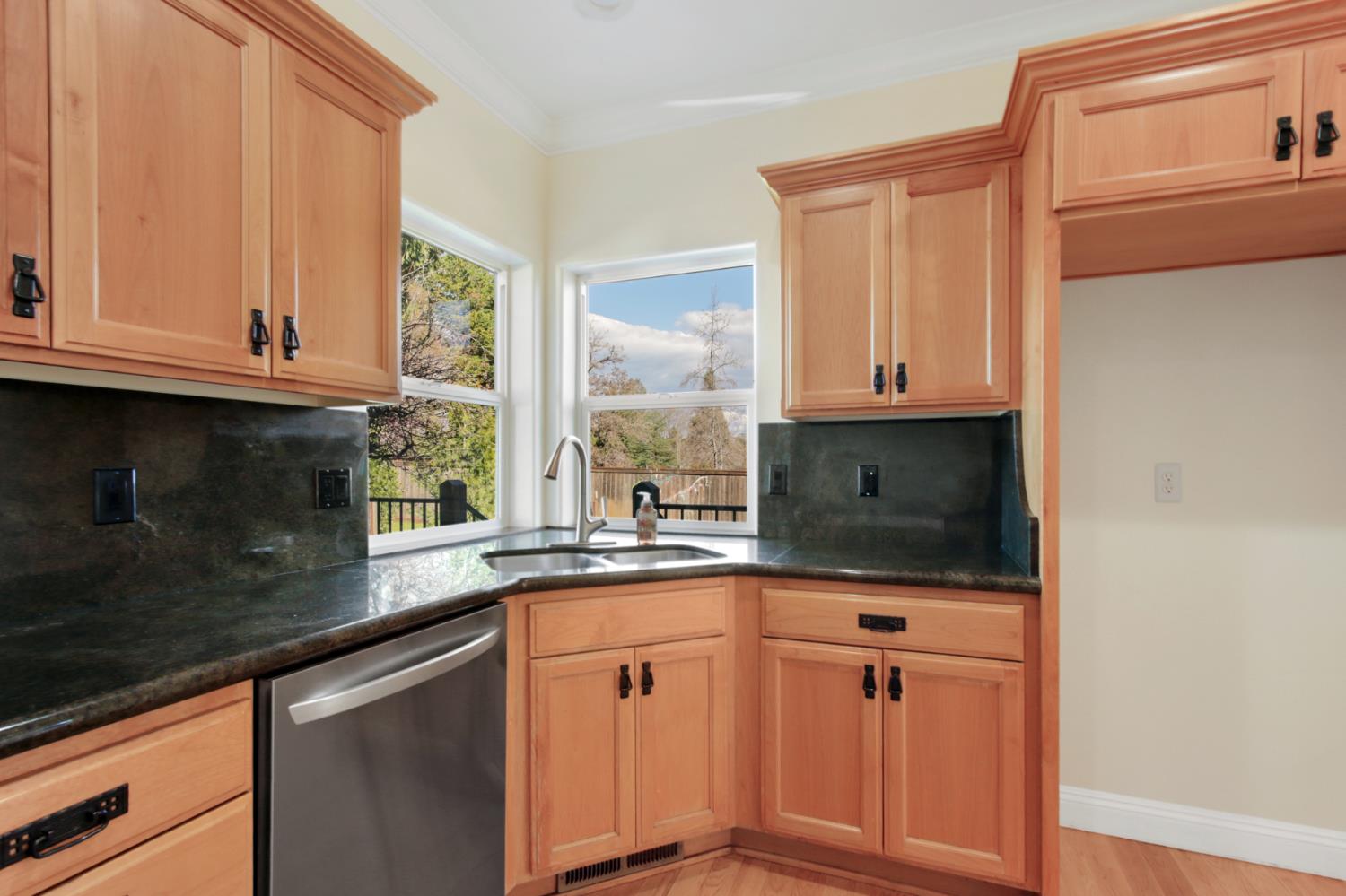 12930 Ridge Road Grass Valley, CA 95945 - Photo 23 of 62 a kitchen with granite countertop white cabinets and black appliances