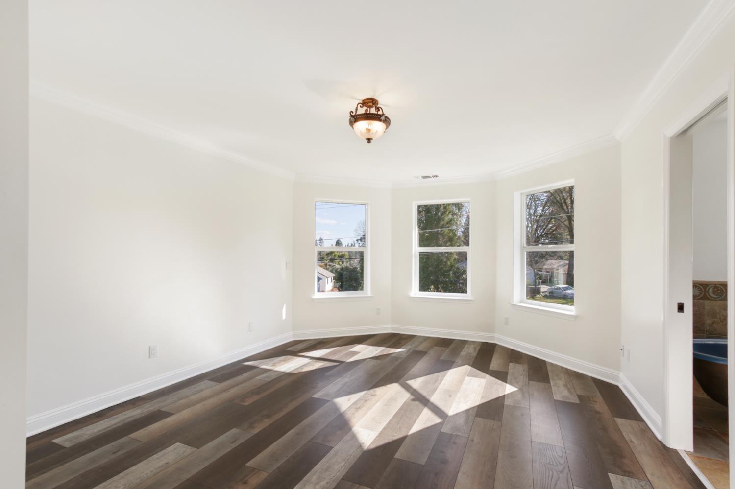 12930 Ridge Road Grass Valley, CA 95945 - Photo 29 of 62 an empty room with wooden floor and windows