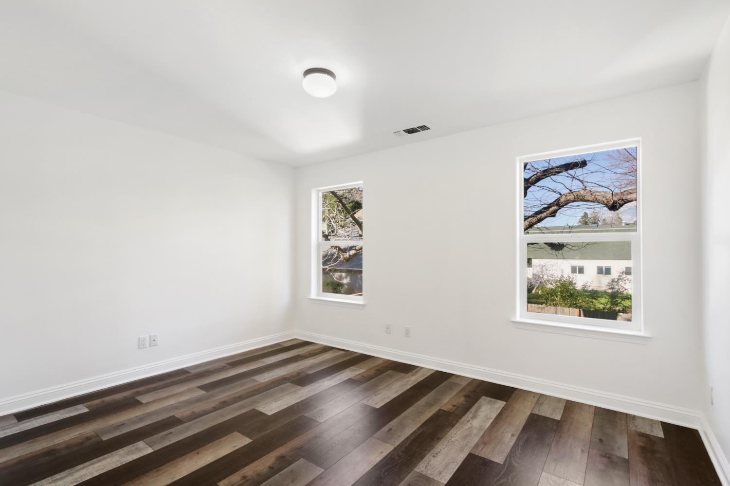 12930 Ridge Road Grass Valley, CA 95945 - Photo 40 of 62 an empty room with wooden floor and windows