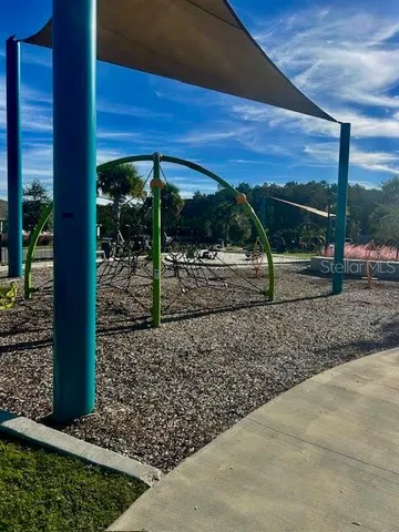 a view of a swimming pool with lawn chairs and plants