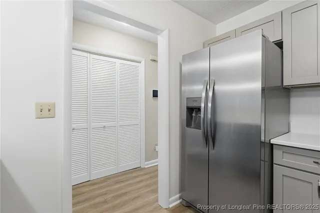 a kitchen with a refrigerator and wooden floor
