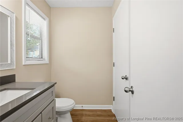 a bathroom with a granite countertop toilet and a sink