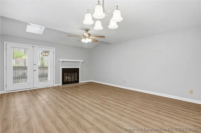a view of an empty room with a window and fireplace