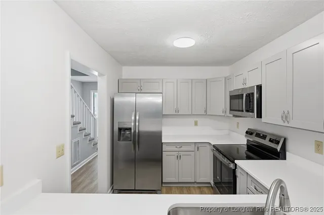 a kitchen with stainless steel appliances a refrigerator sink and microwave