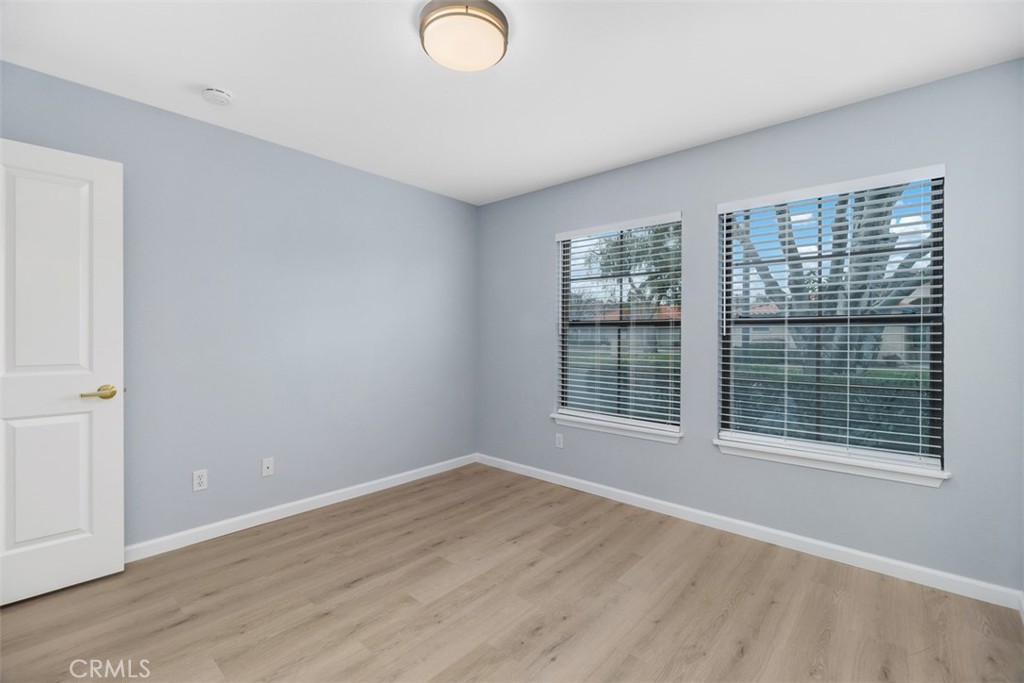 1078 Merrill Circle Hemet, CA 92545 - Photo 15 of 33 a view of an empty room with wooden floor and a window