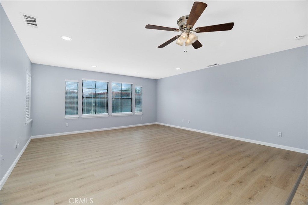 1078 Merrill Circle Hemet, CA 92545 - Photo 6 of 33 an empty room with wooden floor fan and windows