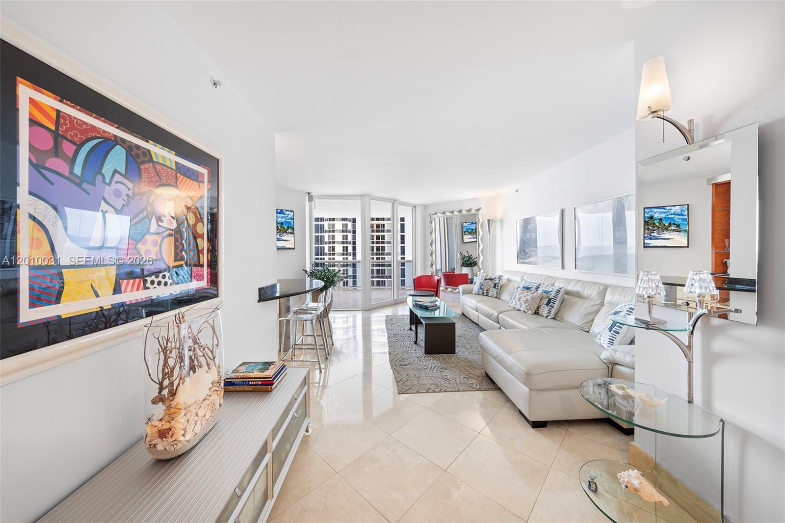 4779 Collins Avenue, Unit 2404 Miami Beach, FL 33140 - Photo 2 of 26 a living room with furniture and a large window