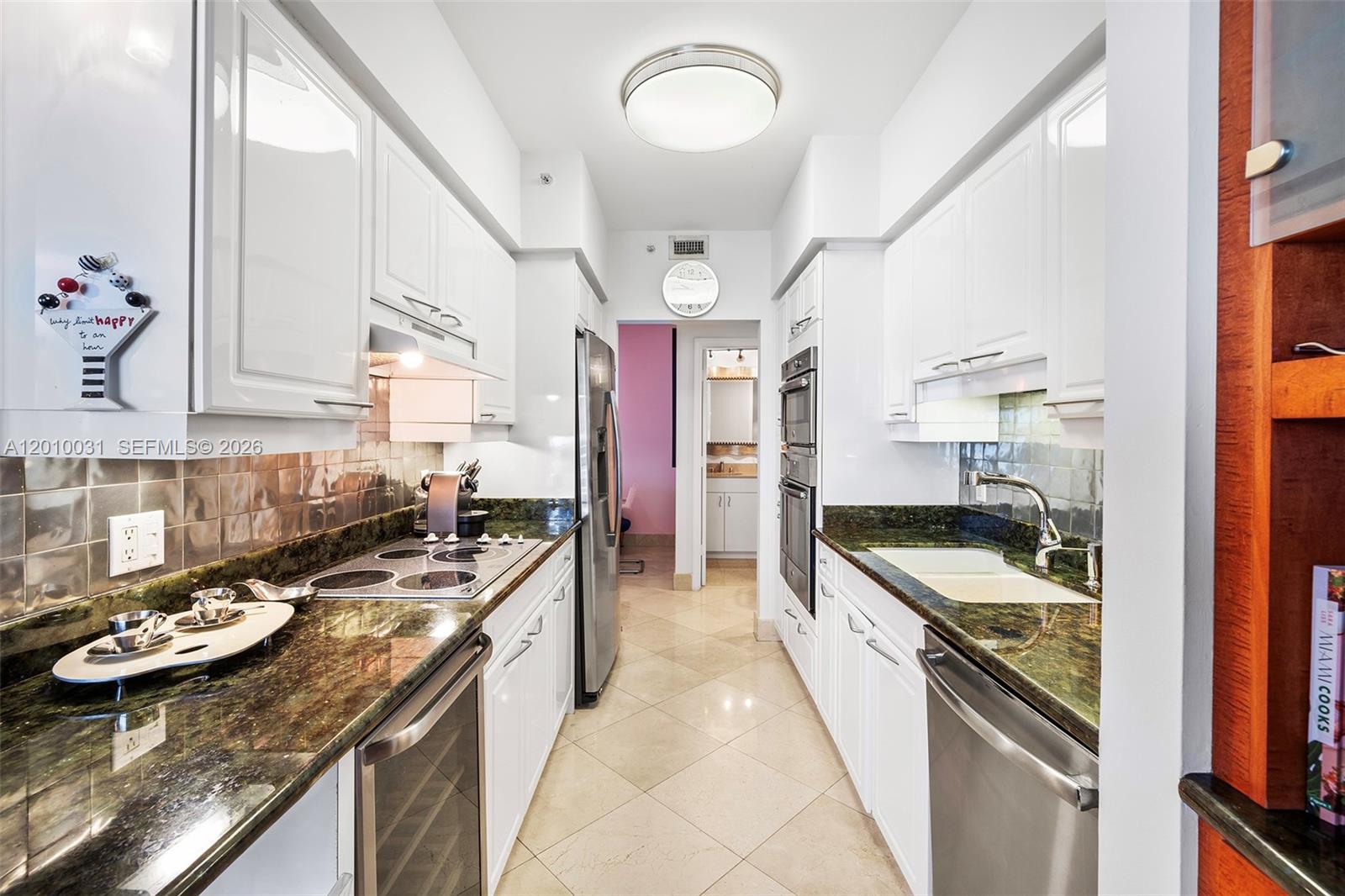 4779 Collins Avenue, Unit 2404 Miami Beach, FL 33140 - Photo 6 of 26 a large kitchen with stainless steel appliances granite countertop a stove and a sink