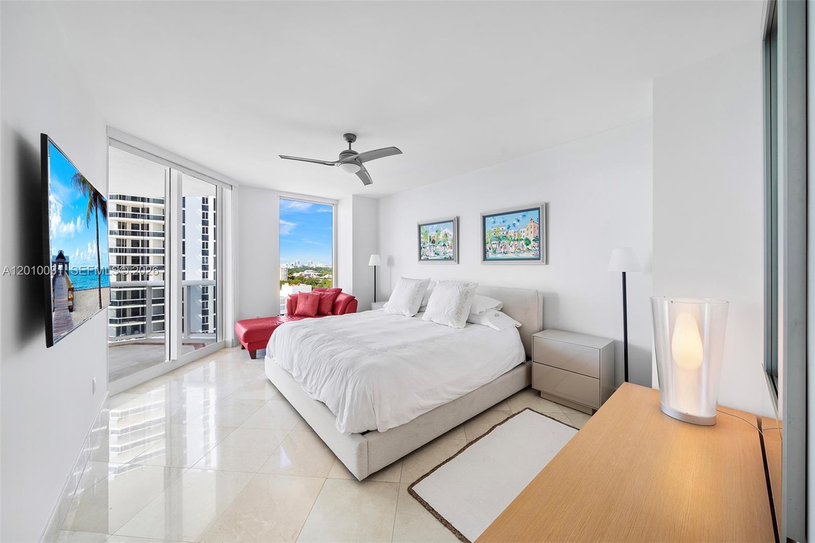 4779 Collins Avenue, Unit 2404 Miami Beach, FL 33140 - Photo 7 of 26 a bedroom with a large bed and a chandelier