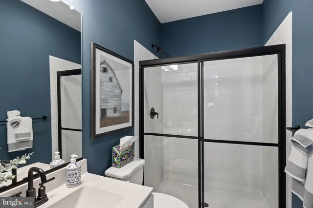 a bathroom with a sink mirror and shower