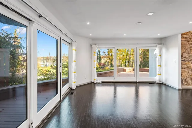a view of a big room with wooden floor and windows
