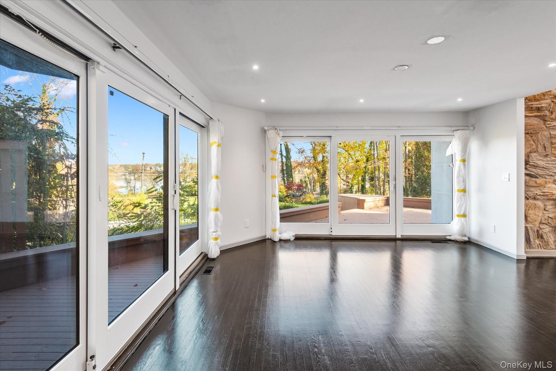 369 East Shore Road Great Neck, NY 11023 - Photo 11 of 50 a view of a big room with wooden floor and windows