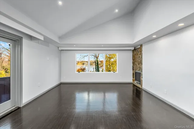 an empty room with window and wooden floor