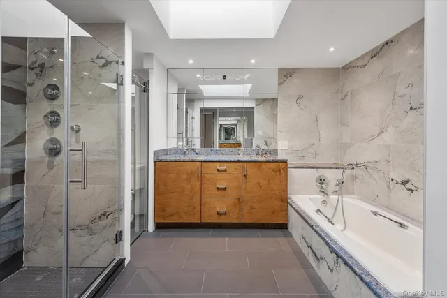 a bathroom with a granite countertop sink a bathtub and a shower