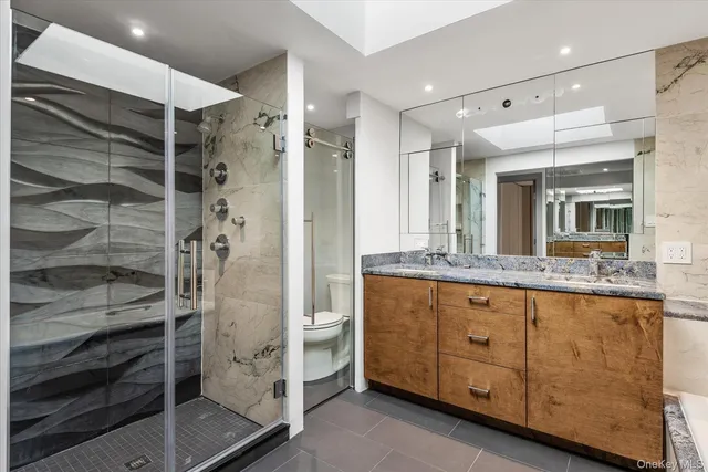 a bathroom with a granite countertop sink mirror and shower
