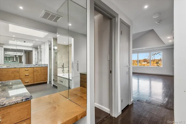 a view of a bathroom with tub shower and mirror