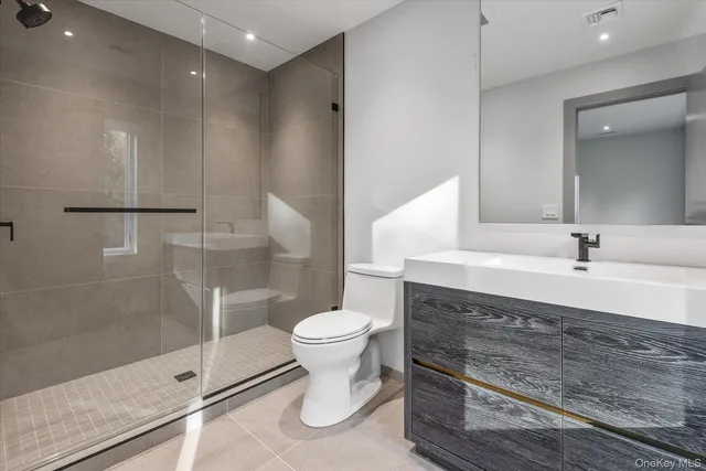 a bathroom with a double vanity sink toilet and shower