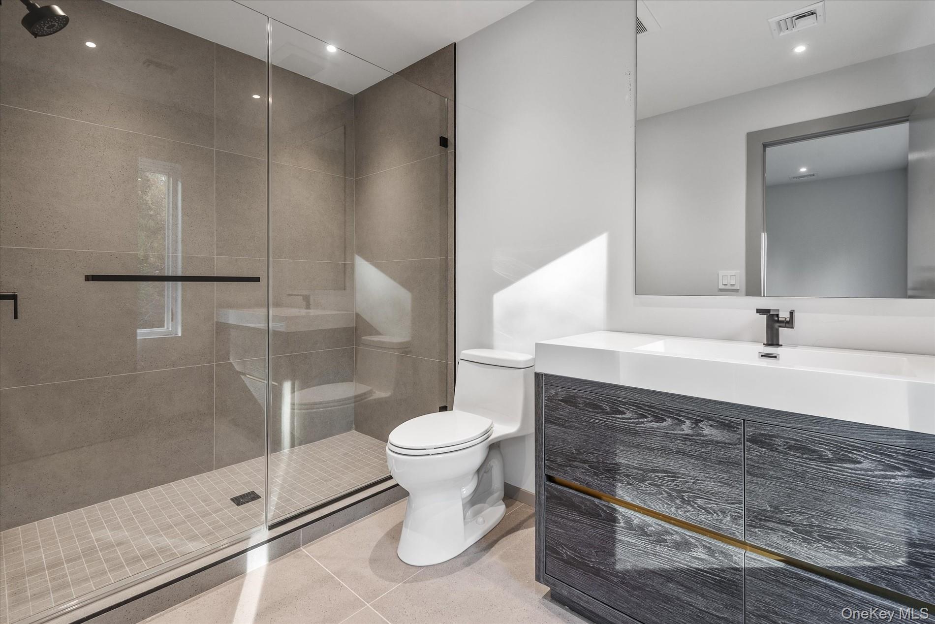 369 East Shore Road Great Neck, NY 11023 - Photo 35 of 50 a bathroom with a double vanity sink toilet and shower