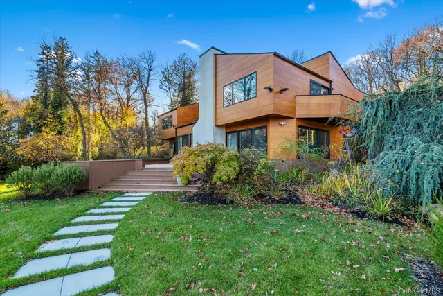a front view of a house with a big yard and potted plants