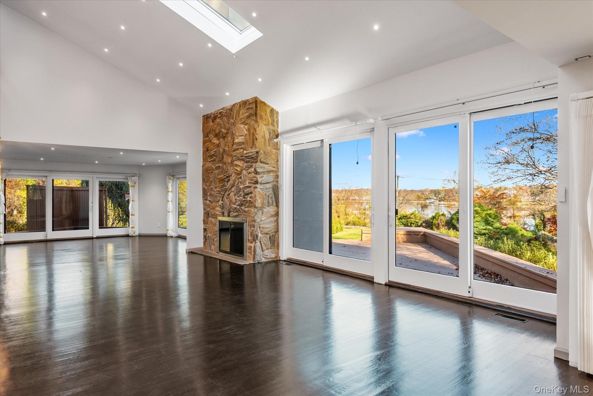 369 East Shore Road Great Neck, NY 11023 - Photo 7 of 50 an empty room with wooden floor and windows