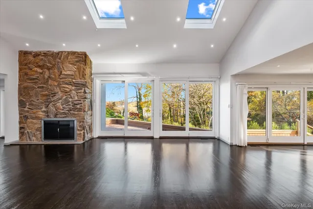 an empty room with wooden floor and a fireplace