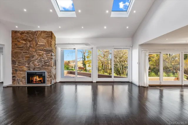 an empty room with wooden floor and a fireplace