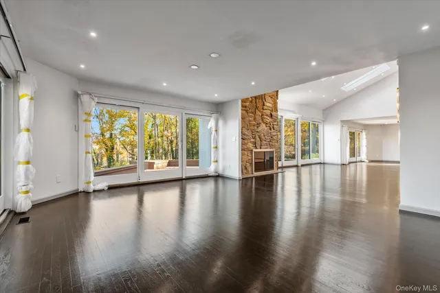 a view of empty room with wooden floor and floor to ceiling window