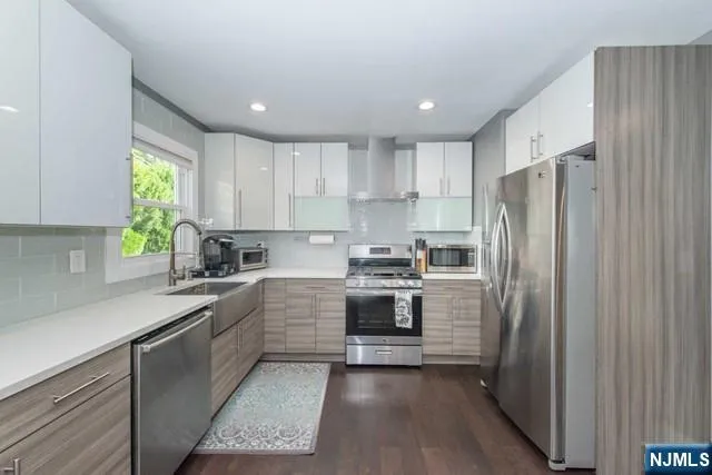 a kitchen with stainless steel appliances granite countertop a refrigerator sink and stove