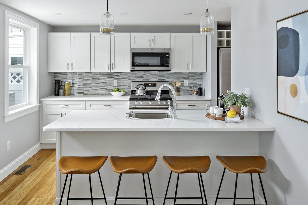 a kitchen with stainless steel appliances a stove a sink and a microwave