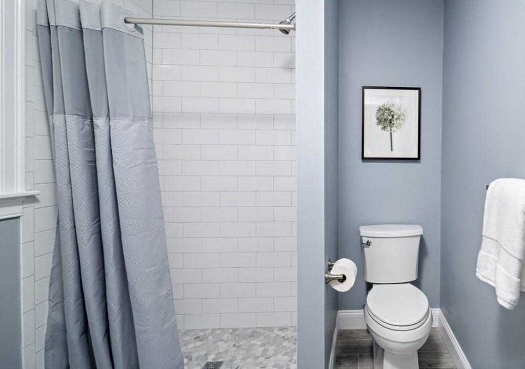 4 Spring St Place Cambridge, MA 02141 - Photo 8 of 12 a white toilet sitting next to a shower curtain
