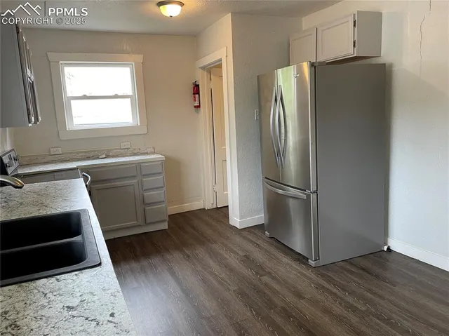 a kitchen with stainless steel appliances a refrigerator sink and wooden floor
