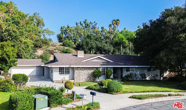 a view of a house with garden and trees