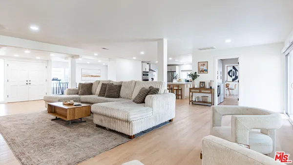 a kitchen with stainless steel appliances kitchen island wooden floors and white cabinets