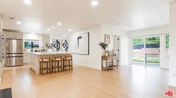 a kitchen with stainless steel appliances granite countertop a sink a stove a refrigerator and a oven with wooden floor