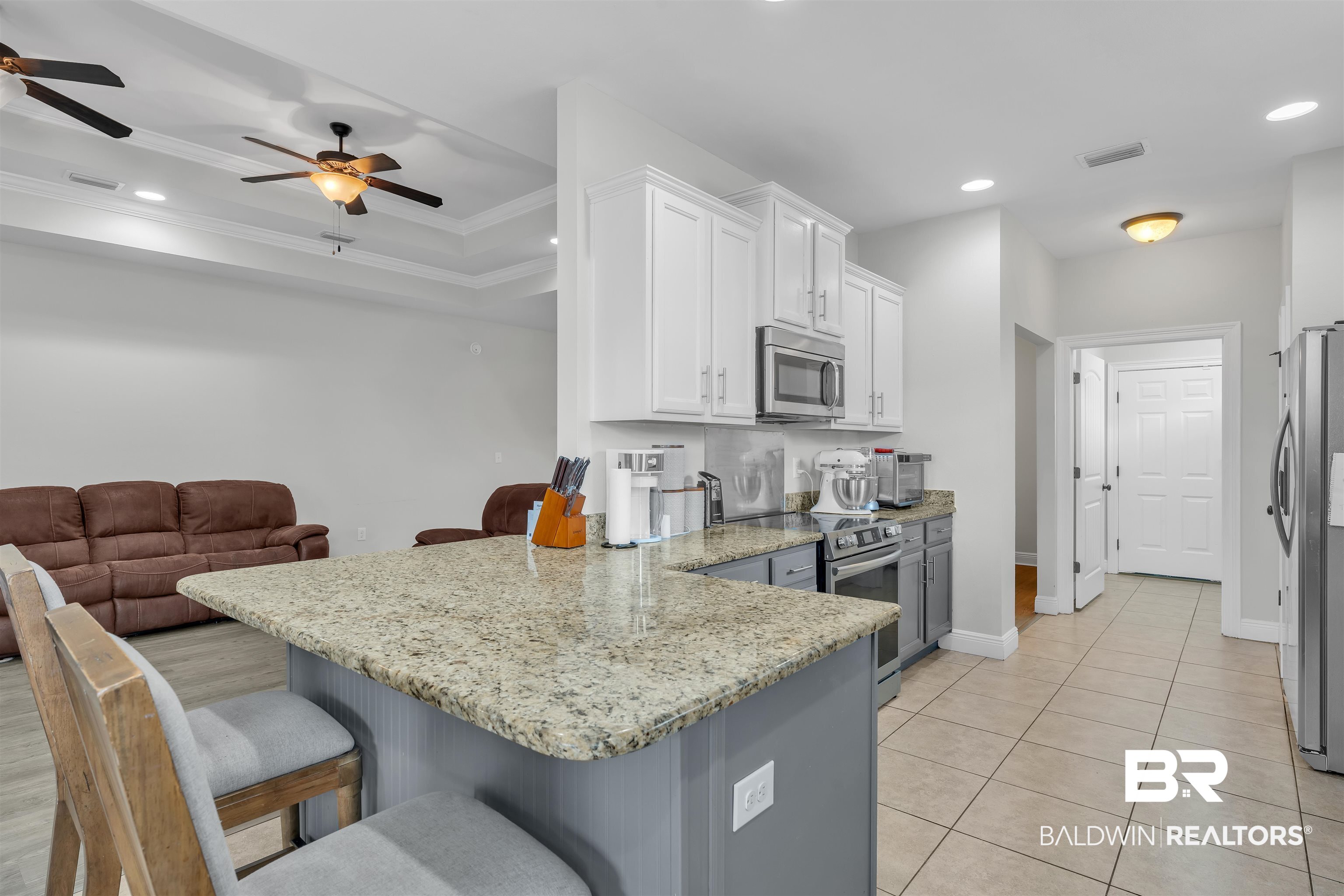 22565 Nana Loop East Silverhill, AL 36576 - Photo 11 of 26 Kitchen with a peninsula, a ceiling fan, stainless steel appliances, white cabinets, and visible vents