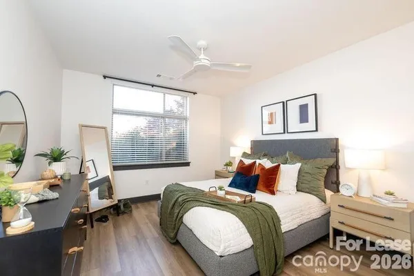 a bedroom with a bed and wooden floor