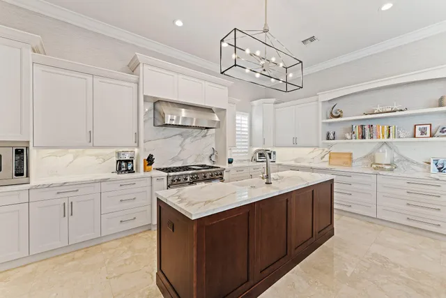 a kitchen with stainless steel appliances granite countertop a sink a stove and a refrigerator
