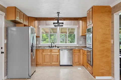 a kitchen with stainless steel appliances granite countertop a refrigerator and a sink
